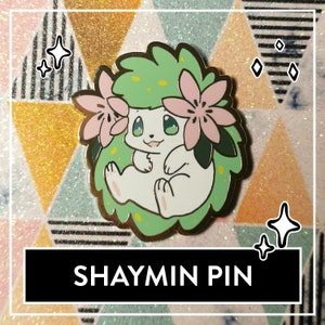 May include: A gold-colored enamel pin featuring a cartoon Shaymin, a Pokemon, in its Land Forme. The Pokemon is white with green hair and pink flowers. The pin has a glossy finish and is set against a glittery background.