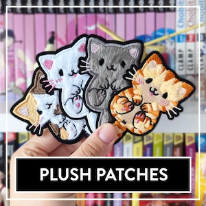 Könnte beinhalten: Vier Plüsch-Katzen-Patches in verschiedenen Farben und Posen. Die Patches sind aus weichem, flauschigem Stoff gefertigt und haben gestickte Details. Die Patches sind perfekt, um jedem Projekt einen Hauch von Verspieltheit zu verleihen.