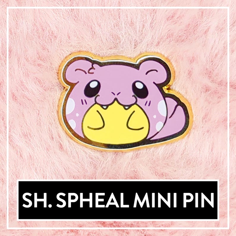 May include: A gold-colored enamel pin featuring a cartoon Spheal, a Pokemon, with a pink body, yellow belly, and white spots. The pin is on a pink fuzzy background. The text "SH.SPHEAL MINI PIN" is below the pin.
