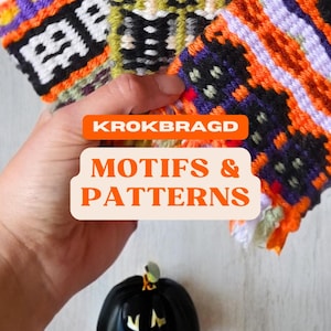 Puede incluir: Primer plano de una mano sosteniendo tiras de tela tejidas de colores con varios patrones. La tela está etiquetada como "KROKBRAGD MOTIFS & PATTERNS". En el fondo hay una calabaza negra con una cara tallada.