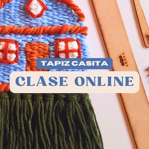 May include: A handmade tapestry in the shape of a house, featuring blue, orange, and white yarn. The tapestry has a green fringe at the bottom and the text "TAPIZ CASITA" and "CLASE ONLINE". Wooden tools are visible in the background.