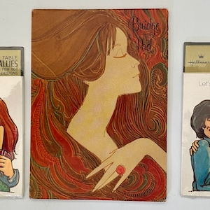 May include: Two sets of Hallmark "Let's take a break" table tallies. Each set features a cartoon couple with red hair and brown hair. The couple is holding a deck of cards. The background is a red, orange, and yellow abstract design. The text "Bridge Pad" is on the center card.