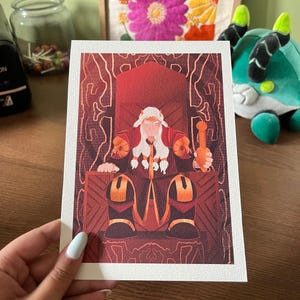 May include: A print featuring a figure seated on a throne, holding an object. The artwork uses a palette of red, orange, and brown. The figure has white hair and is wearing a red robe. The throne is ornate with a detailed design.