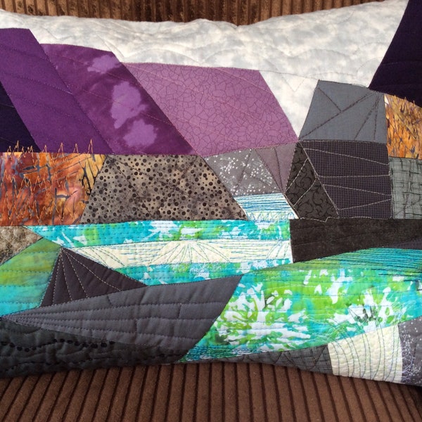 Une housse de coussin en patchwork paysager représentant Glen Coe