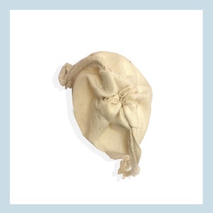 May include: A white cotton drawstring pouch with a gathered top and a long cord.