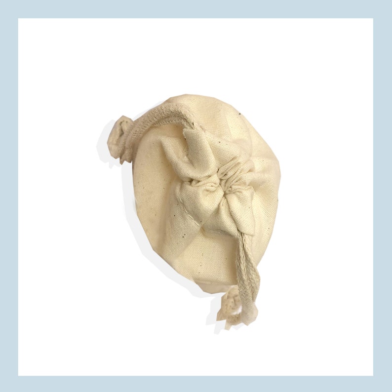 May include: A white cotton drawstring pouch with a gathered top and a long cord.