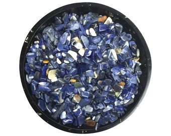 May include: A bowl filled with small blue, white, and brown tumbled stones. The stones are various shapes and sizes.