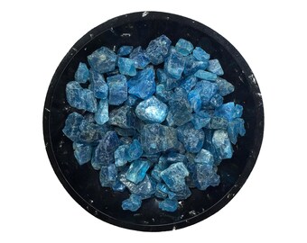 May include: A black bowl filled with blue aquamarine crystals.