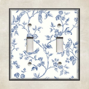 May include: A white light switch cover with a blue and white floral pattern featuring birds. The pattern is reminiscent of toile fabric.