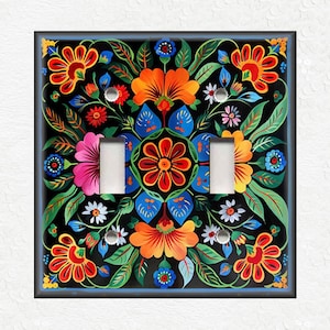 May include: A light switch cover with a colorful floral design. The design features red, orange, yellow, blue, green, and white flowers on a black background.