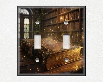 May include: A decorative light switch cover featuring an image of a large, antique book with gold accents. The background shows a library with bookshelves and a door. The cover has two light switch openings and a black border.