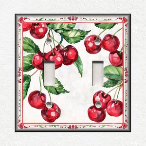 May include: A light switch cover with a watercolor design of red cherries on green leaves. The cherries are arranged in a cluster and have a white background.