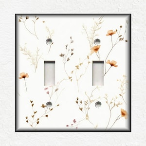May include: A white light switch cover with a floral pattern featuring brown stems and orange flowers.