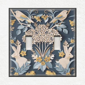 May include: A light blue light switch cover with a floral pattern featuring white rabbits, yellow flowers, and blue birds. The pattern is reminiscent of paper cutouts.
