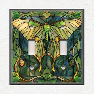 May include: A light switch cover with a stained glass design featuring a green and yellow butterfly with intricate details.