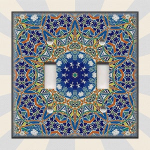 May include: A decorative light switch cover with a blue, orange, and green geometric pattern. The pattern is intricate and features a mandala-like design.