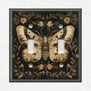 May include: A black light switch cover with a gold and white butterfly illustration surrounded by floral designs.