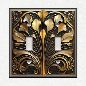 May include: A double light switch cover plate with a decorative design featuring gold-colored floral motifs on a black background.