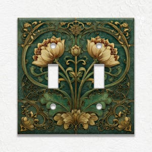 May include: Decorative double light switch cover with a floral design. The cover features a teal background with gold and cream-colored flowers and leaves. The design is an Art Nouveau style.