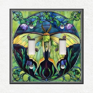 May include: A light switch cover featuring a stained glass design of a green and yellow luna moth with purple flowers and green leaves.