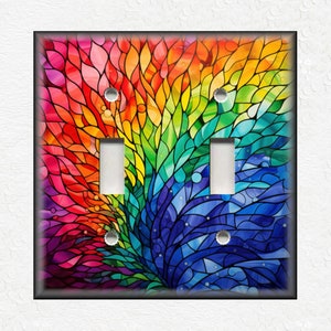 May include: A double light switch cover with a colorful stained glass design featuring a rainbow of colors, including red, orange, yellow, green, blue, and purple. The design is abstract and resembles a swirling pattern of leaves.