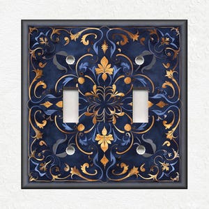 May include: A decorative light switch cover with a blue and gold floral pattern. The design features intricate swirls and leaves.