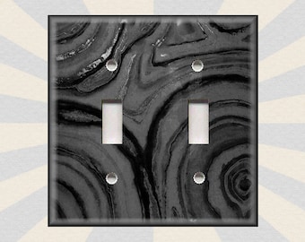 May include: A black and white marble patterned light switch cover plate with two toggle switches.