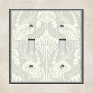 May include: A light gray double light switch cover with a white floral pattern. The pattern features stylized flowers and leaves.
