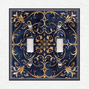 May include: A decorative light switch cover with a blue background and gold intricate floral pattern.