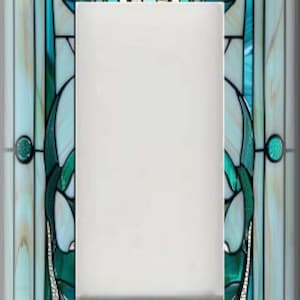 May include: A decorative light switch cover with a stained glass design. The cover features a rectangular center with a detailed border in shades of teal, white, and silver. The design includes floral and abstract patterns, creating a unique and artistic look.