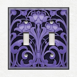 May include: A decorative double light switch cover with a floral Art Nouveau design. The cover features a raised, lavender-colored pattern against a dark blue background. The design includes stylized flowers and flowing lines, with two toggle switches.