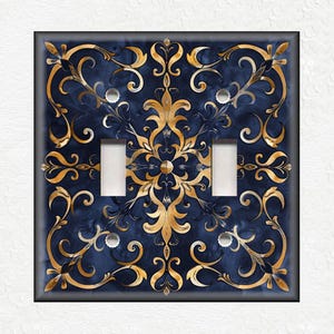 May include: A double light switch cover with a decorative design. The design features a blue background with gold swirls and floral patterns.