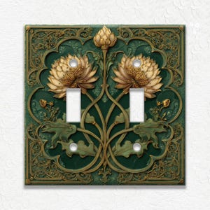 May include: Decorative double light switch cover with a floral design. The cover features a dark green background with gold and tan floral accents. The design includes two large flowers, leaves, and intricate gold filigree.