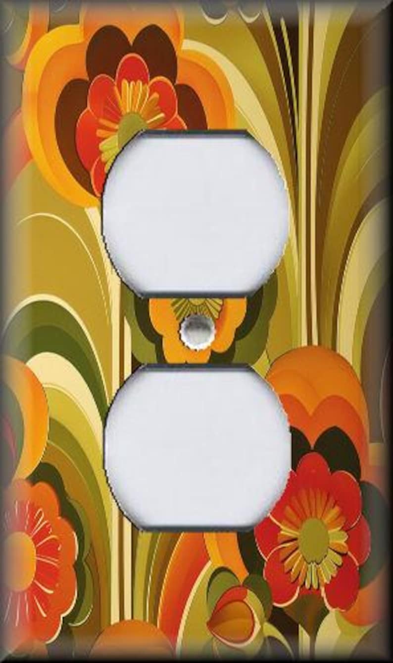 May include: A decorative wall outlet cover featuring a retro floral design. The cover has two white outlet openings and is adorned with orange, red, and yellow flowers against a green and brown background. The design evokes a vintage, 1970s aesthetic.