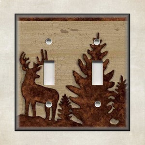 May include: A light switch cover with a rustic design featuring a deer silhouette and pine trees. The background is a distressed beige with brown accents.