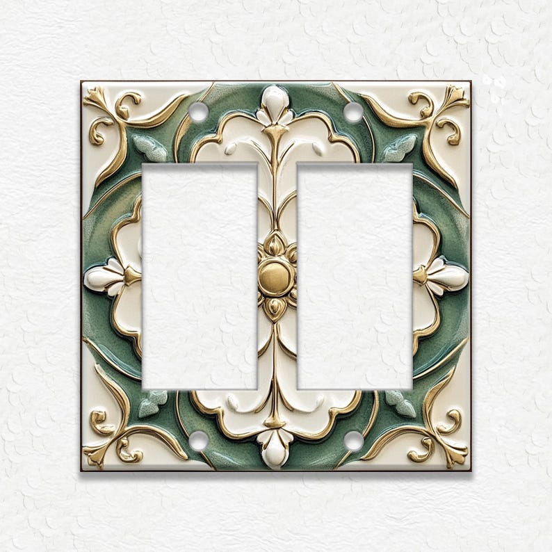 May include: Decorative double light switch cover with a floral design. The cover features a square shape with a cream-colored background, accented with gold and teal green floral patterns. The center has two rectangular openings.