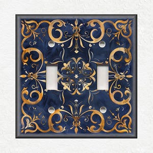 May include: A double light switch cover with a blue and gold design. The design features intricate swirls and floral patterns.