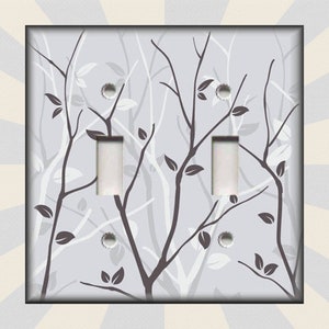 May include: A light gray double light switch cover with a white and gray stylized tree branch design.