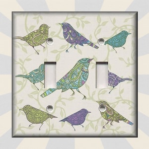 May include: Light switch cover with a decorative design featuring colorful birds with intricate patterns on a white background with green vines.
