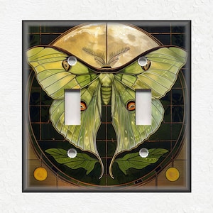 May include: A light switch cover featuring a green luna moth with a yellow moon and green leaves on a dark green background.