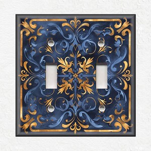 May include: A decorative light switch cover with a blue and gold design. The design features a repeating pattern of stylized floral motifs.