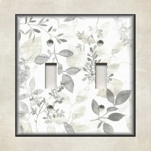 May include: A white light switch cover with a gray watercolor floral pattern. The switch cover has two toggle switches.