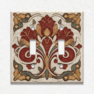 May include: A decorative double light switch cover with an ornate floral design. The cover features a cream-colored background with a detailed pattern in shades of red, gold, and gray. The design includes two switch openings.