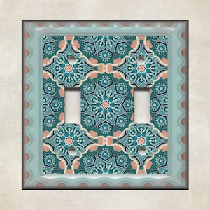 May include: A light blue double light switch cover with a teal, pink, and white patterned design.