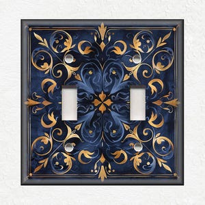 May include: A double light switch cover with a navy blue background and gold filigree design.
