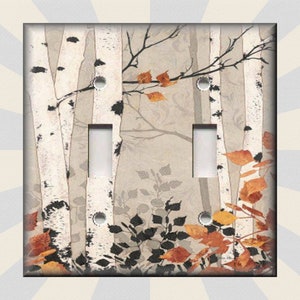 May include: A light switch cover featuring a watercolor painting of birch trees with fall foliage in shades of orange, yellow, and brown. The background is a soft beige color.