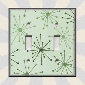 May include: A light green double light switch cover with a repeating pattern of stylized green stars.