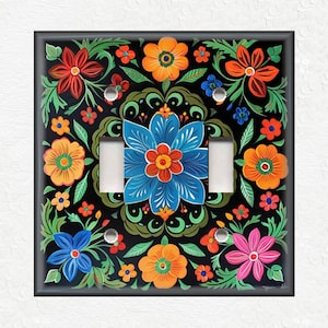 May include: A light switch cover with a colorful floral design. The design features blue, orange, pink, red, and yellow flowers on a black background.