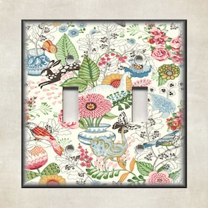 May include: A white light switch cover with a colorful floral pattern featuring birds, butterflies, and rabbits. The pattern is reminiscent of a vintage wallpaper design.