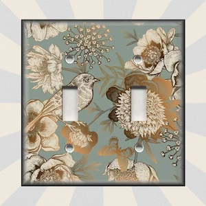 May include: A light blue double light switch cover with a vintage floral pattern in gold and brown. The pattern features birds, butterflies, and flowers.